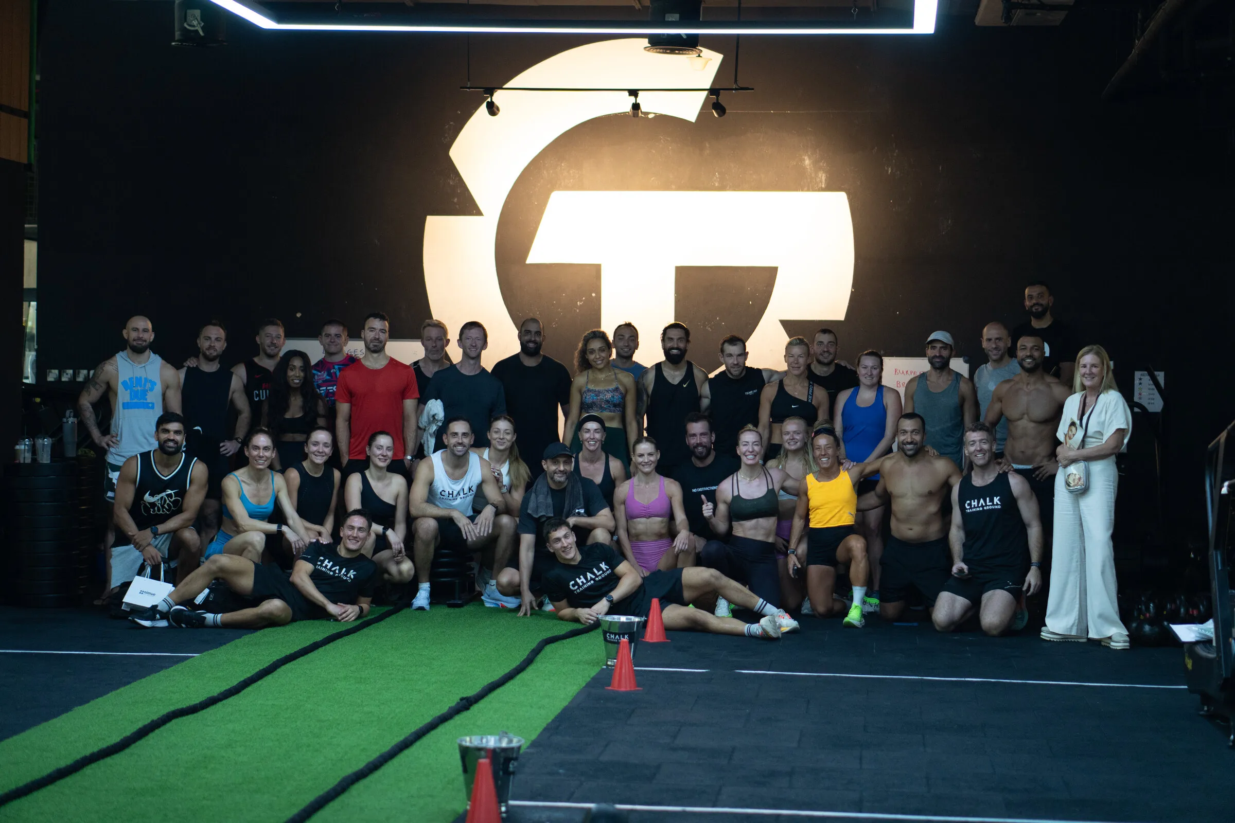 The Chalk Training Ground community in front of the gym logo wall