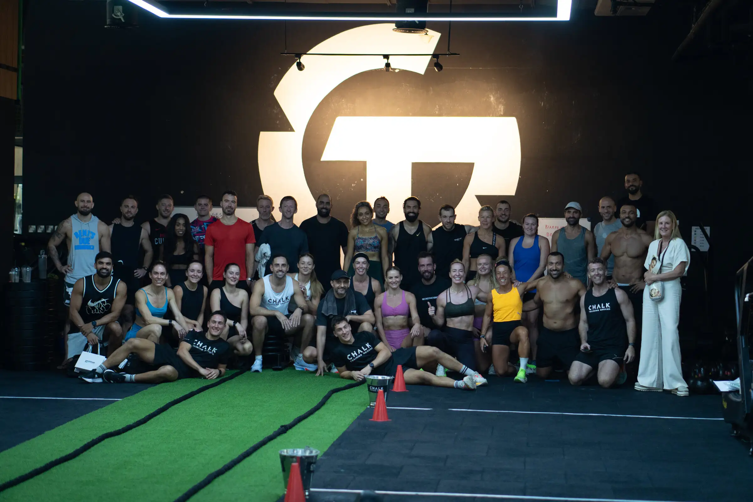 The Chalk Training Ground community in front of the gym logo wall