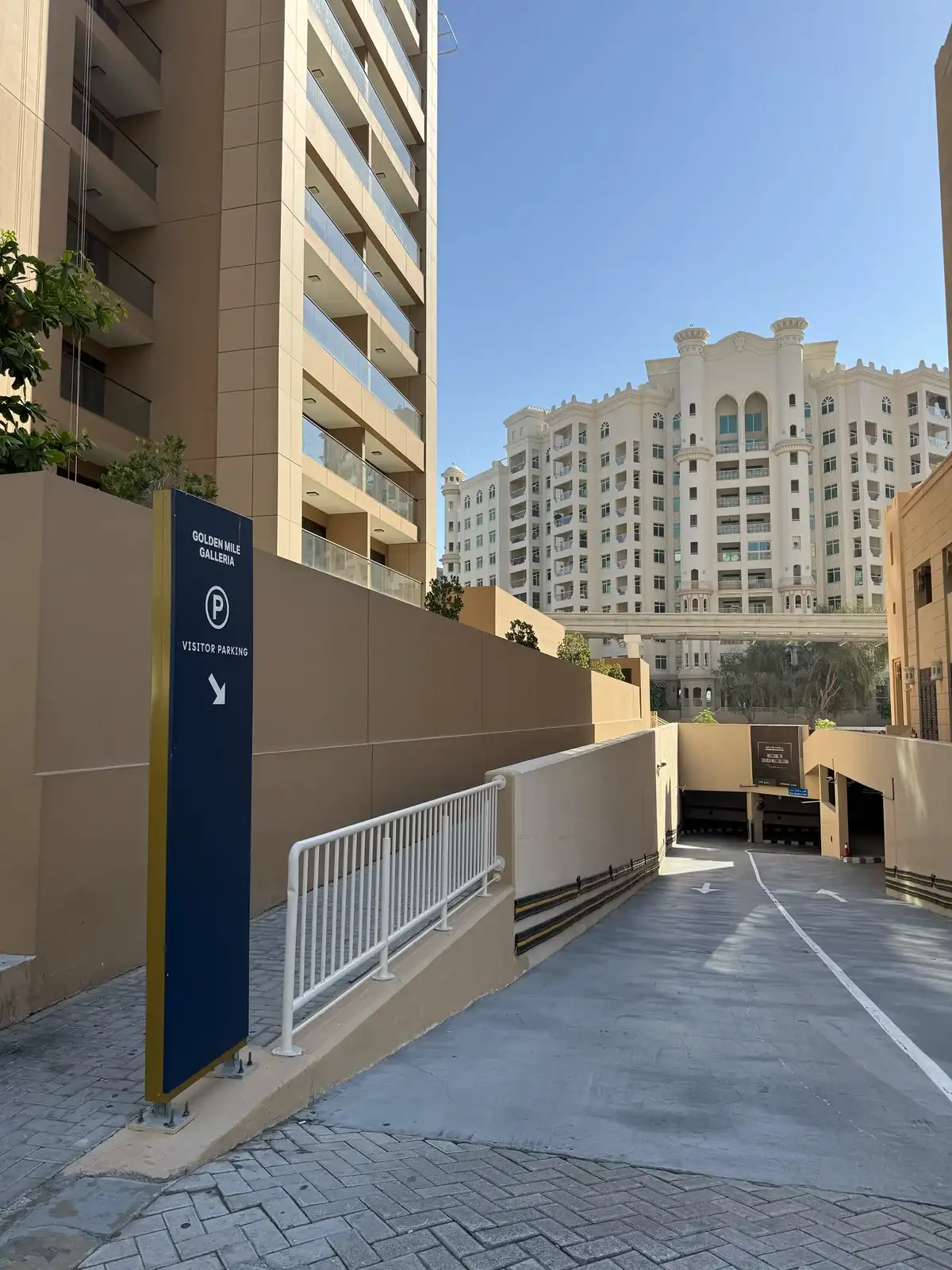 Blue Golden Mile Galleria visitor parking sign pointing down the ramp to the car park